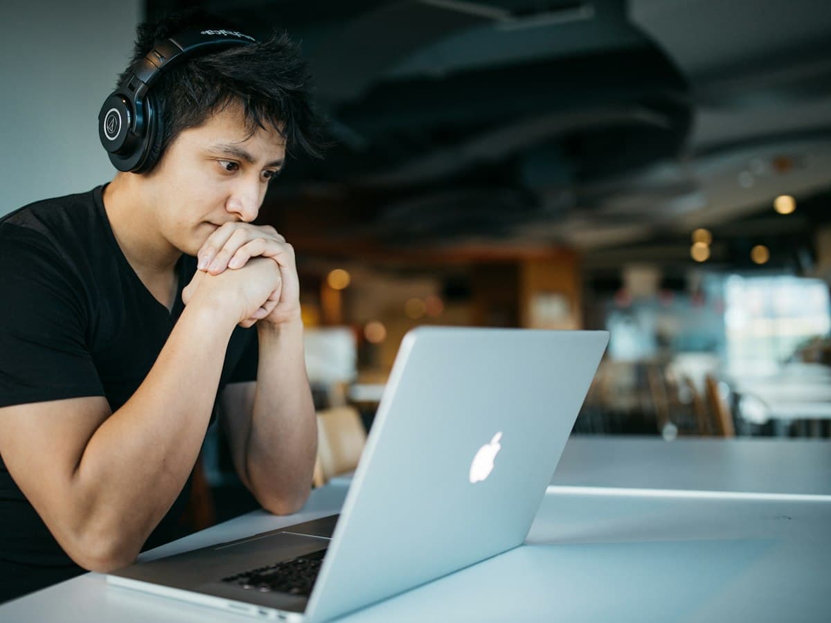 A student with headphones studying on a laptop